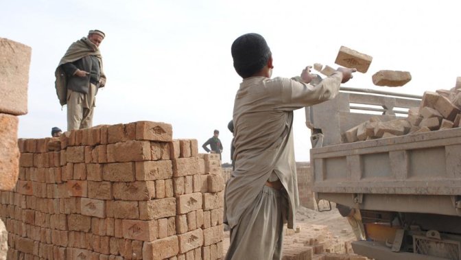 Hazrat Hussain, 10, loads bricks onto a truck. Hazrat doesn’t go to school and works alongside his two teenage brothers at a brick kiln outside Kabul.  